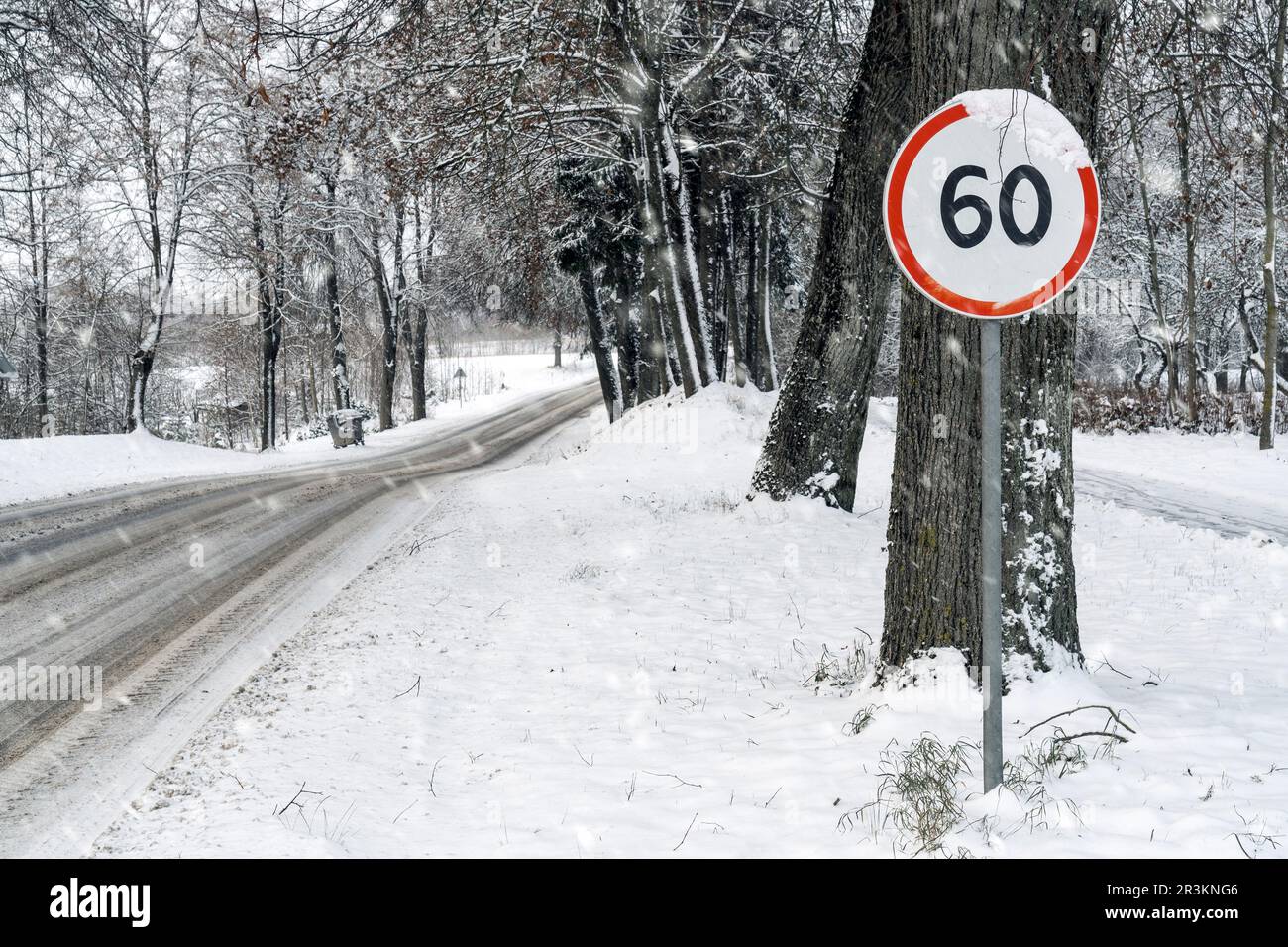 panneau de limitation de vitesse de 60 km/h sur route enneigée Banque D'Images