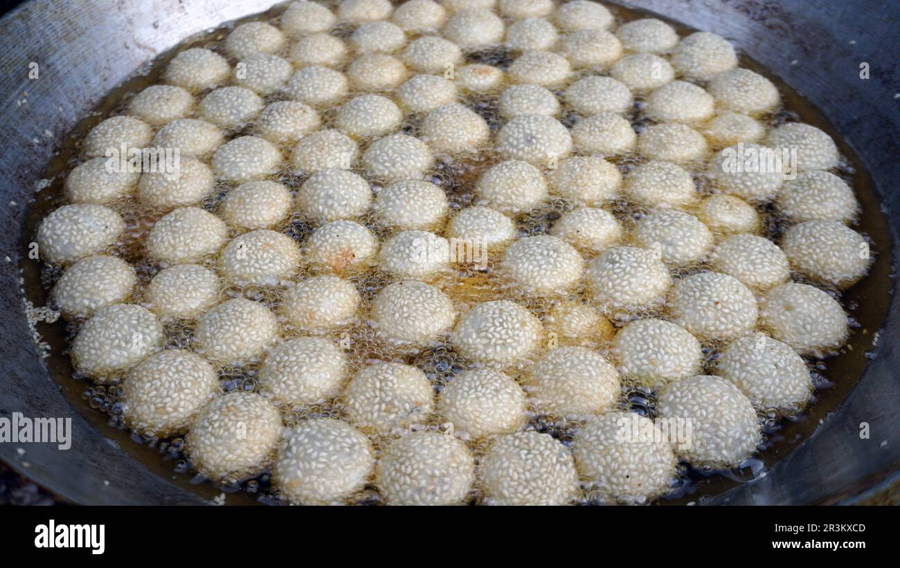 Boule de l'onde ou du sésame frite dans de l'huile bouillante. Banque D'Images
