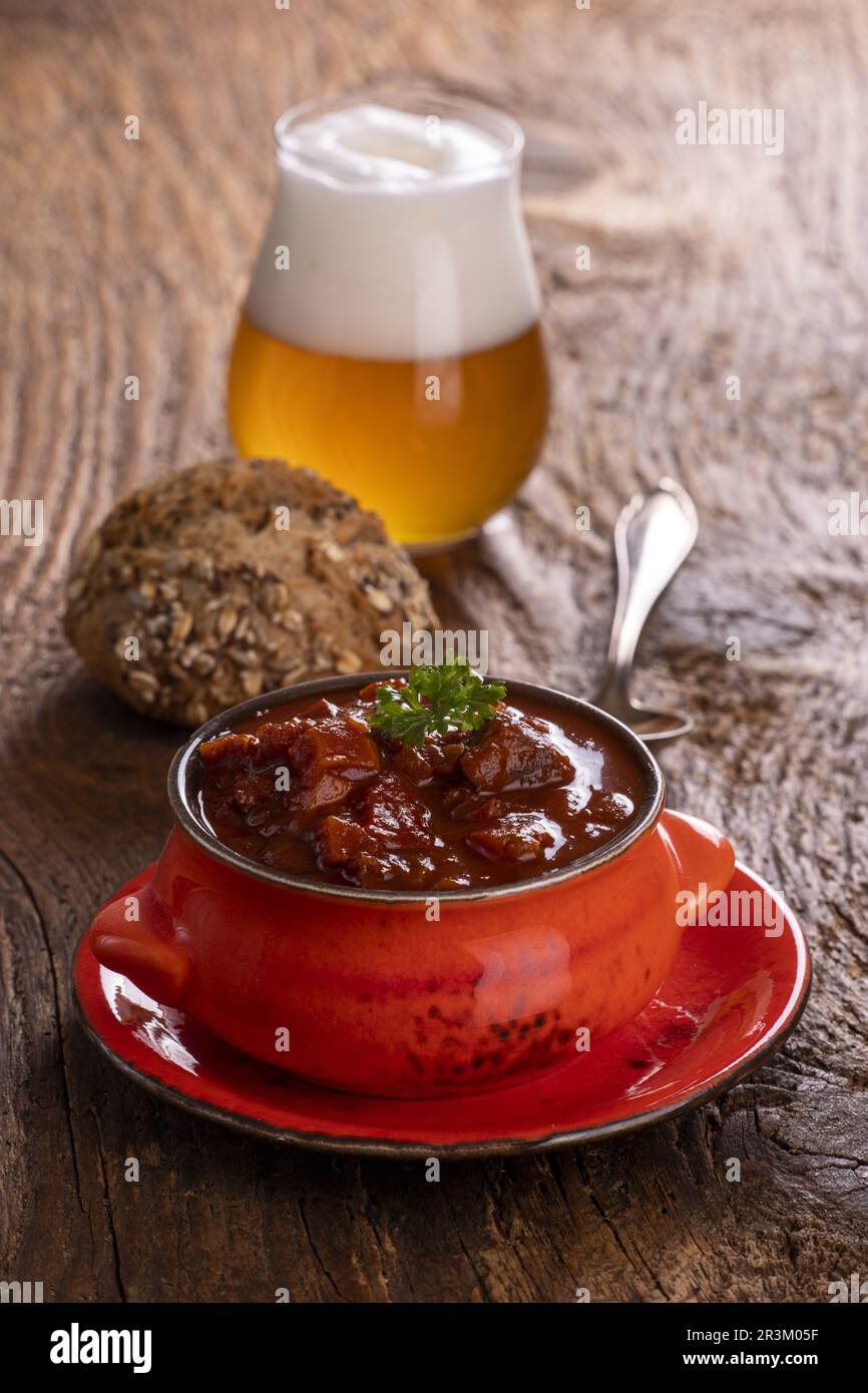 Goulash sur bois sombre avec bière Banque D'Images