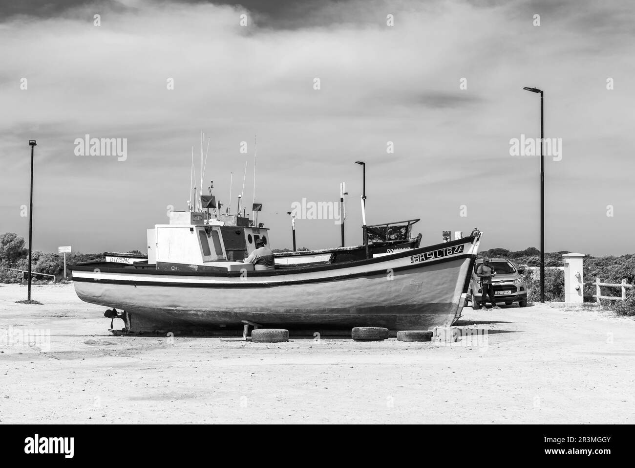 Struisbaai, Afrique du Sud - 21 septembre 2022 : bateaux de pêche au port de Struisbaai, dans la province du Cap occidental. Les personnes sont visibles. Monochrome Banque D'Images