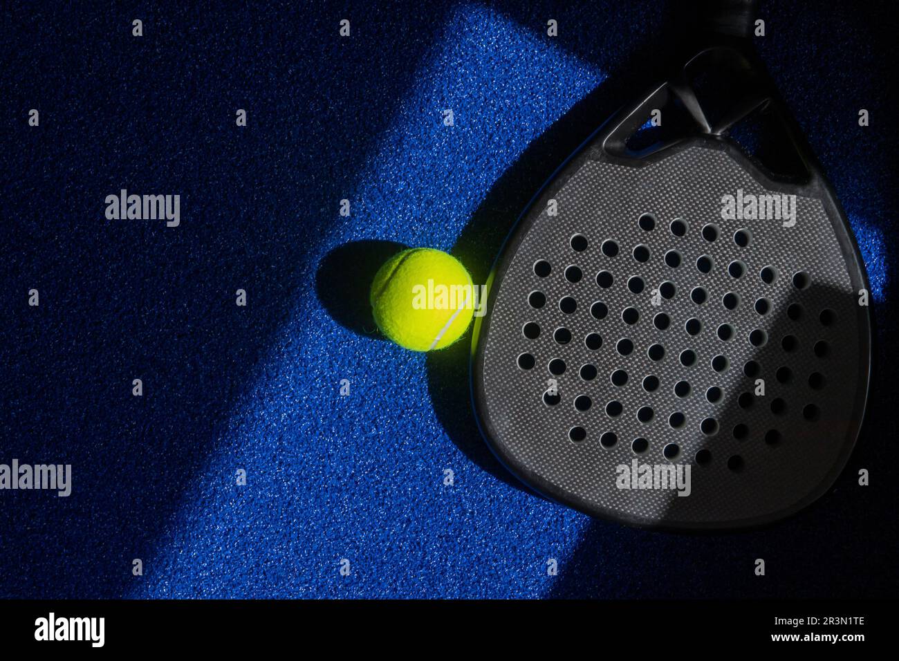 Paddle de tennis professionnelle noire avec éclairage naturel sur fond bleu. Affiche sur le thème du sport horizontal, cartes de vœux, en-têtes, Web Banque D'Images