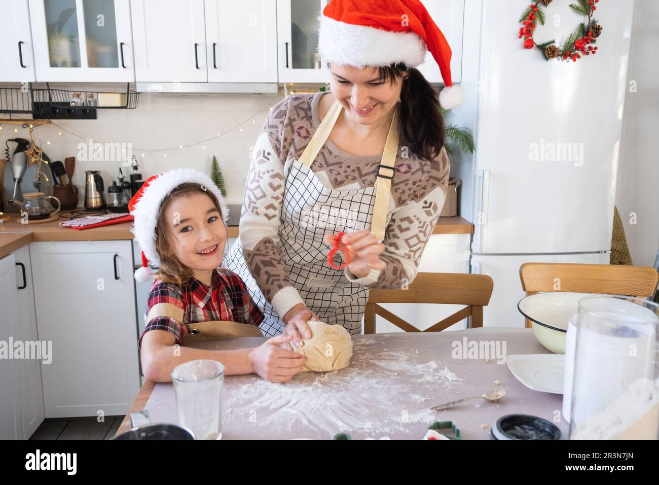 Maman et fille dans la cuisine blanche préparent des biscuits pour Noël et le nouvel an. Jour de famille, préparation pour les vacances, Banque D'Images