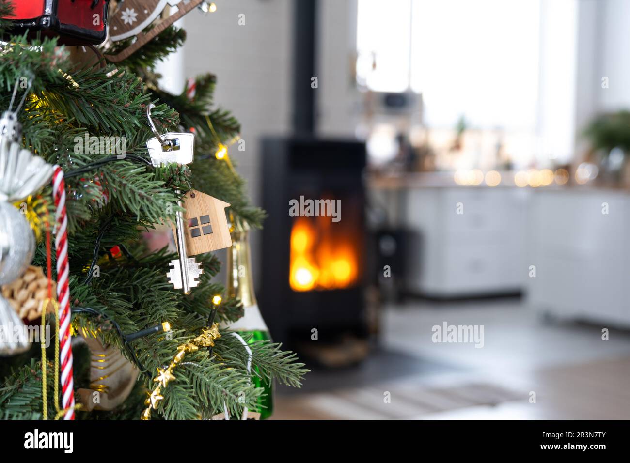 La clé de la maison avec un porte-clés est accrochée sur l'arbre de Noël. Un cadeau pour le nouvel an, Noël. Construction, conception, projet, Mo Banque D'Images