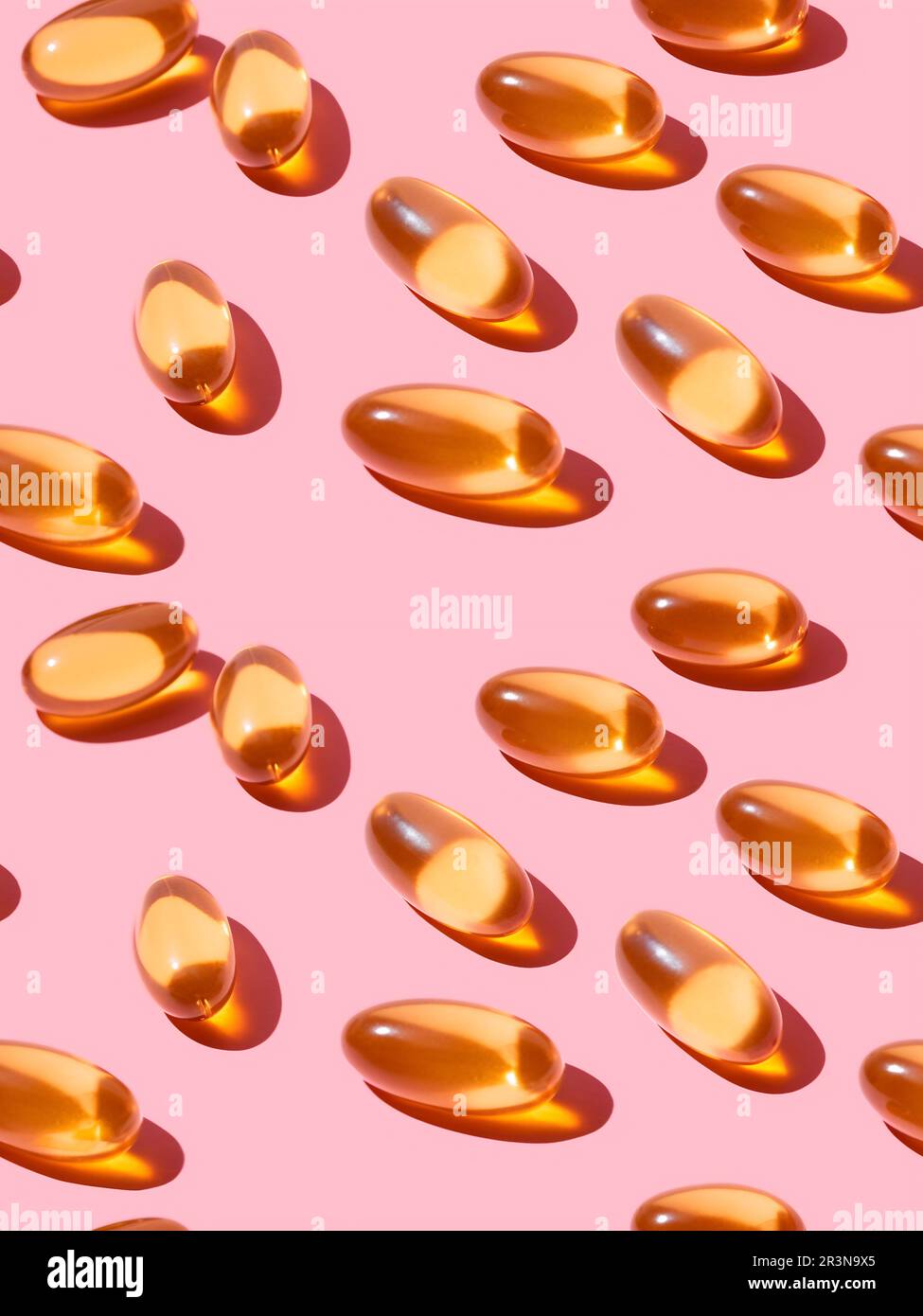 Vue de dessus composition de pilules de vitamine orange éparpillées sur fond rose dans le studio léger Banque D'Images