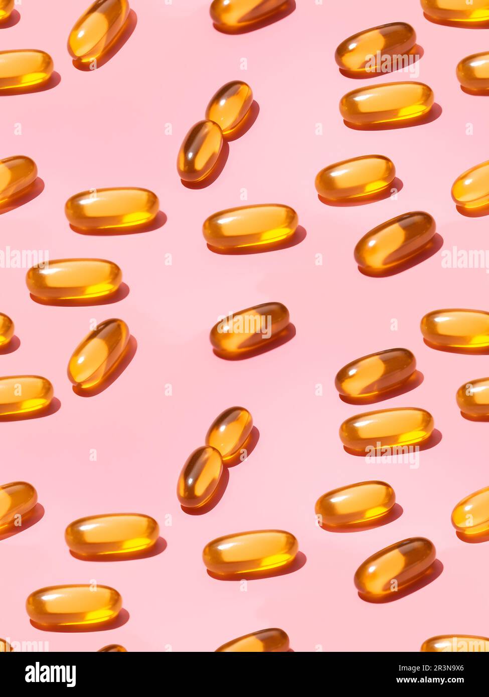 Vue de dessus composition de pilules de vitamine orange éparpillées sur fond rose dans le studio léger Banque D'Images