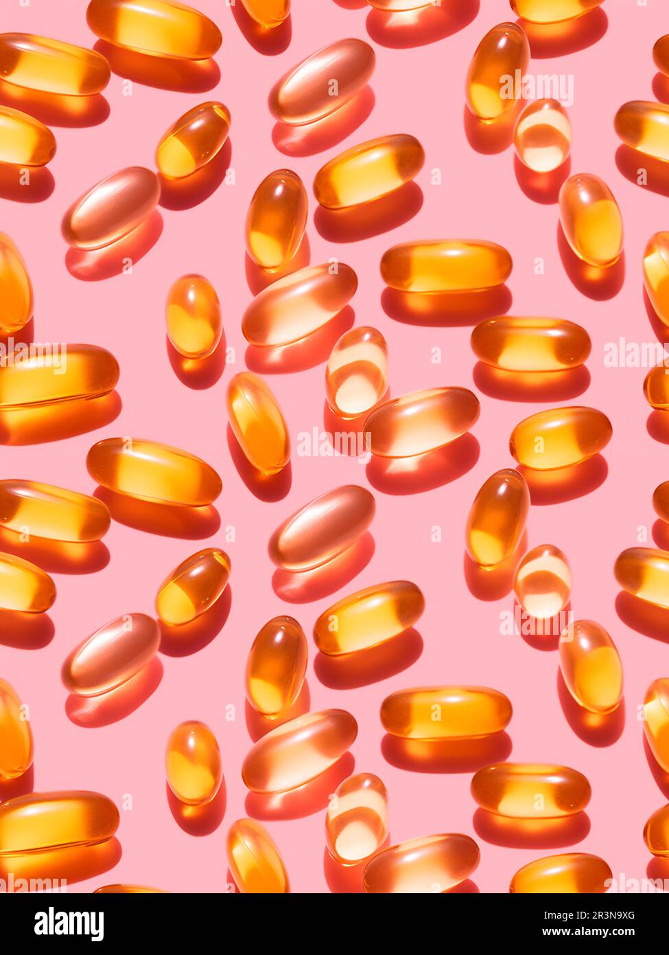 Vue de dessus composition de pilules de vitamine orange éparpillées sur fond rose dans le studio léger Banque D'Images