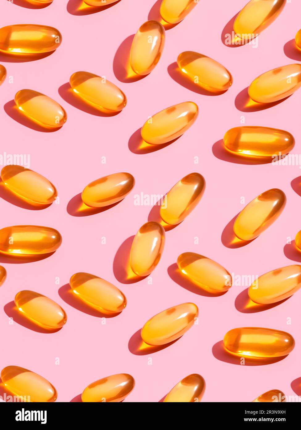 Vue de dessus composition de pilules de vitamine orange éparpillées sur fond rose dans le studio léger Banque D'Images