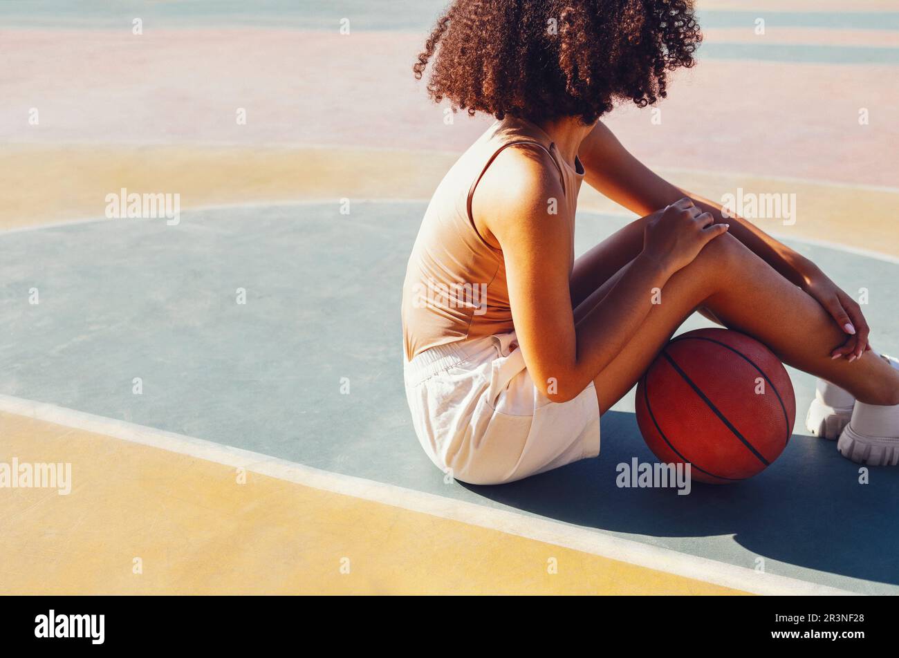 Une jeune fille élégante et fraîche se réunit sur le terrain de basket-ball, jouant au basket-ball à l'extérieur Banque D'Images