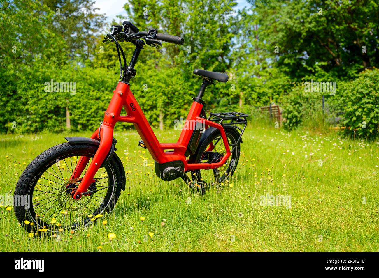 Berlin, Allemagne - 22 mai 2023: Vélo rouge au milieu d'une prairie florale. Banque D'Images