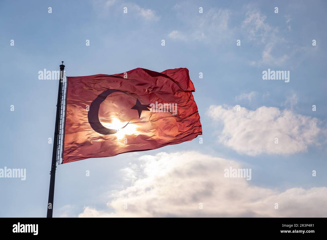 Une photo du drapeau turc contre un ciel bleu nuageux. Banque D'Images
