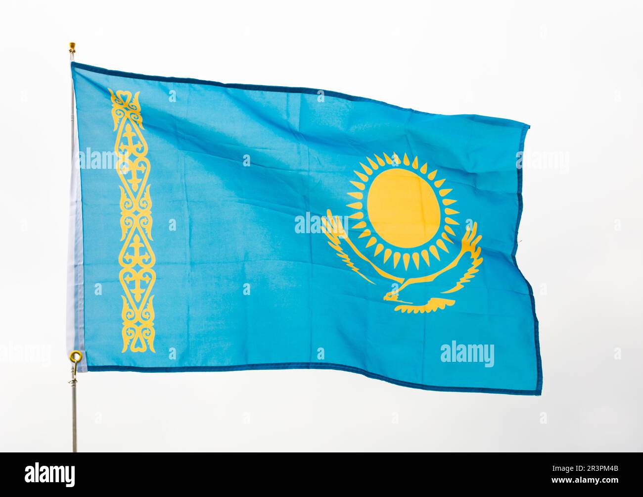 Drapeau national du Kazakhstan agitant sur flagstaff contre le ciel Banque D'Images