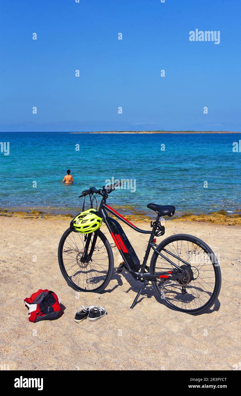 e-bike à la plage d'Elafonisos, femme se baignant dans la mer, Grèce, Péloponnèse, Laconia, Elafonisos Banque D'Images
