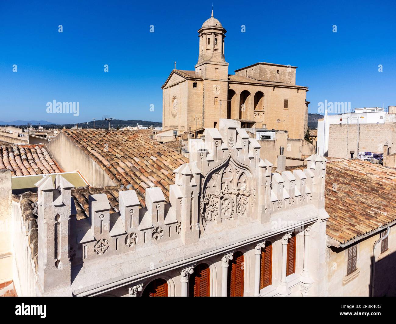 La façade de la Caixa, construite en 1908, dans un style néo-gothique, par Miquel Salvà, et église paroissiale, Llucmajor, Majorque, Iles Baléares, Espagne. Banque D'Images