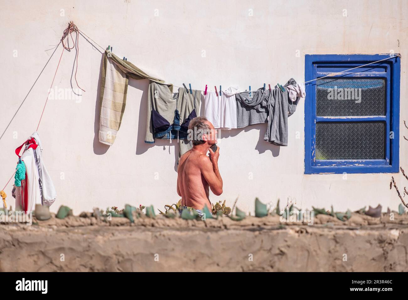 Homme se raser derrière un mur, Essaouira, maroc, afrique. Banque D'Images