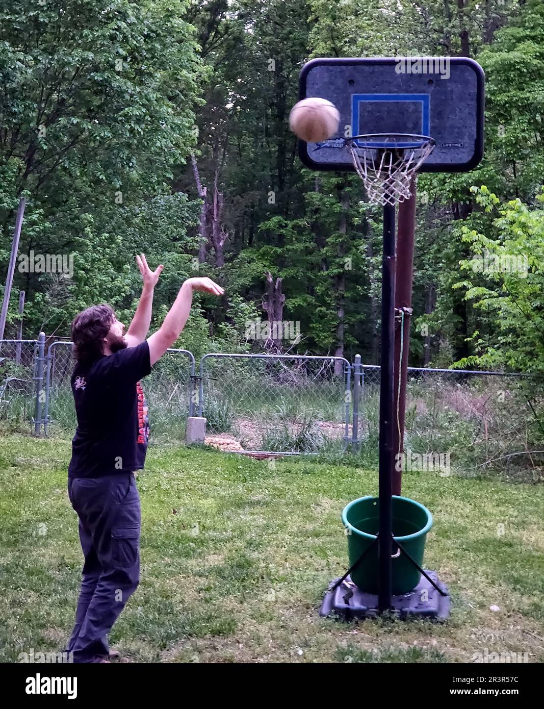 Homme jetant un ballon de basket dehors Banque D'Images