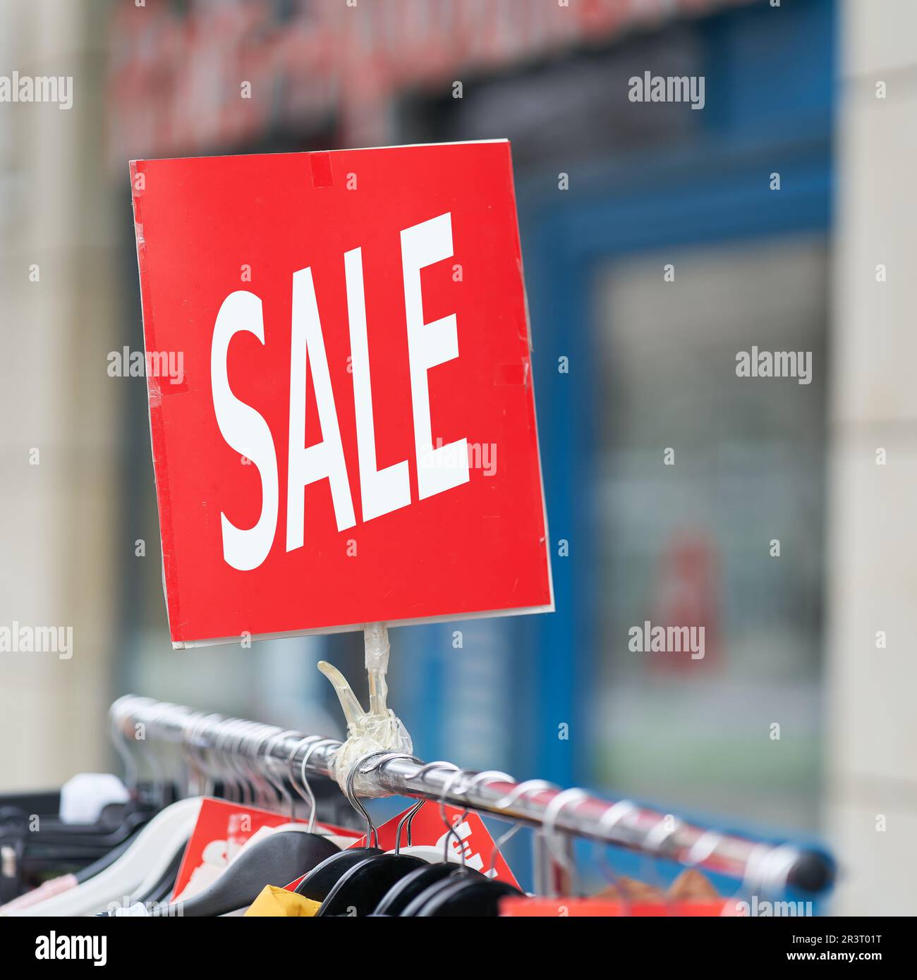 Affiche avec l'inscription Vente de vêtements à prix réduit sur offre spéciale devant un magasin Banque D'Images