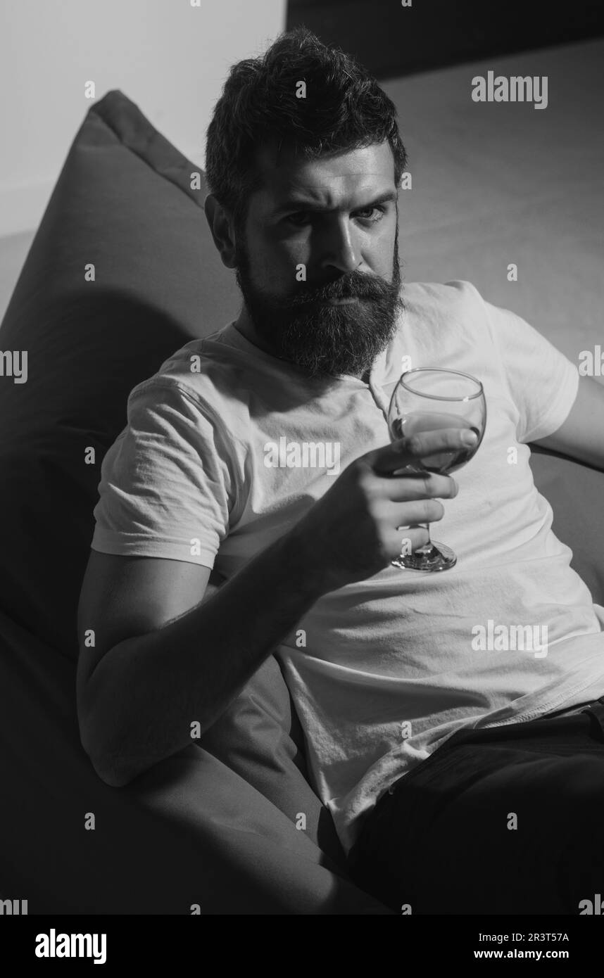 Célébrez seul. Homme barbu avec du vin. Fête à la maison. Hipster avec alcool. Banque D'Images