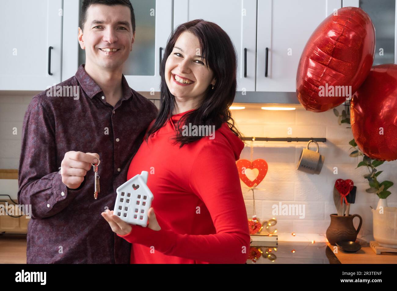 L'homme et la femme amoureux datent à la maison dans la cuisine avec les clés de la maison. Saint-Valentin, couple heureux, histoire d'amour. Nid d'amour, hypothèque Banque D'Images