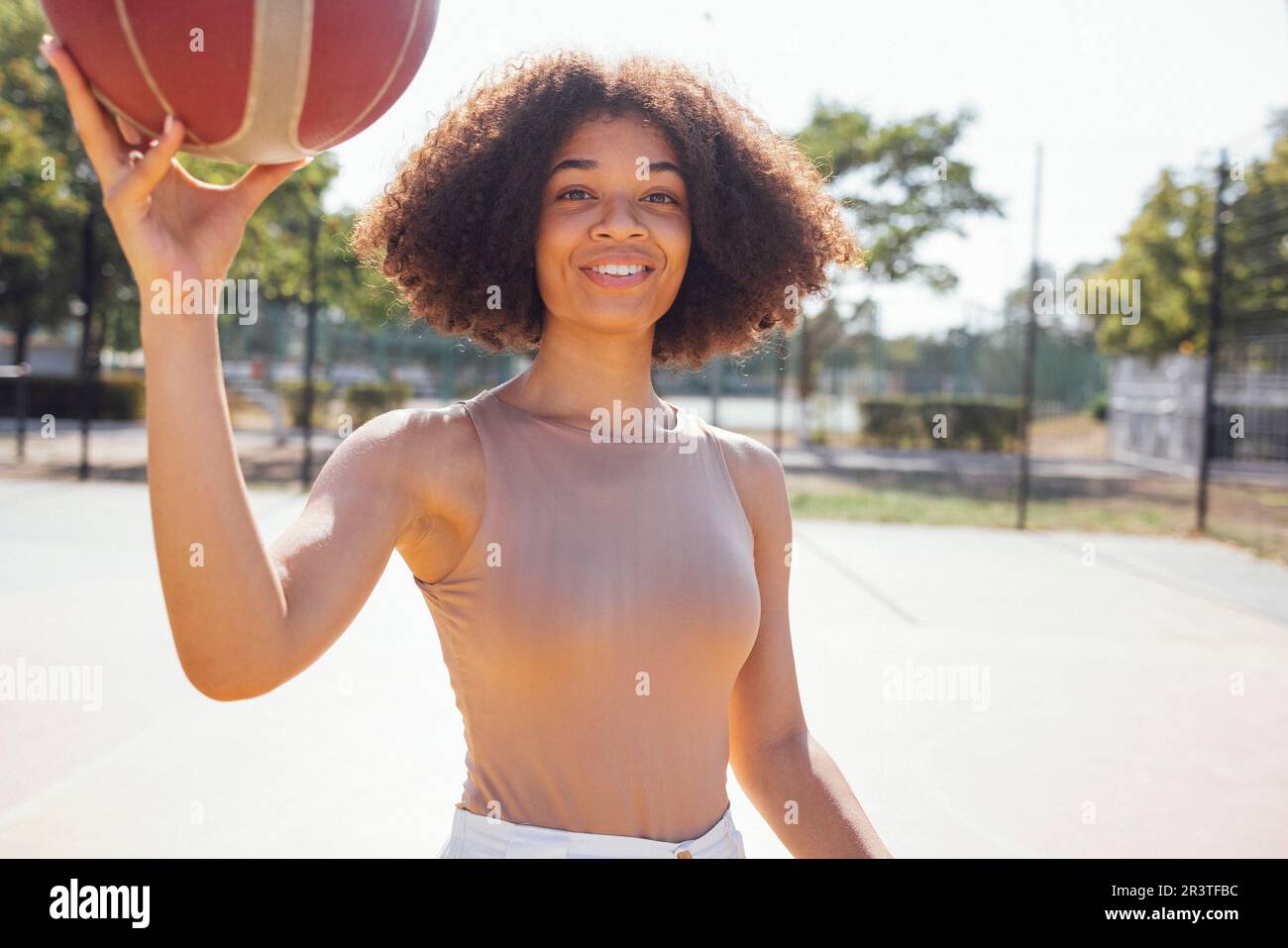 Une jeune fille élégante et fraîche se réunit sur le terrain de basket-ball, jouant au basket-ball à l'extérieur Banque D'Images