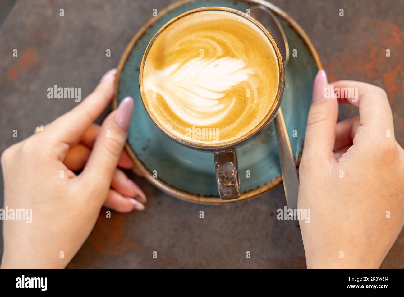 Les femmes tiennent une tasse de cappuccino dans un café Banque D'Images