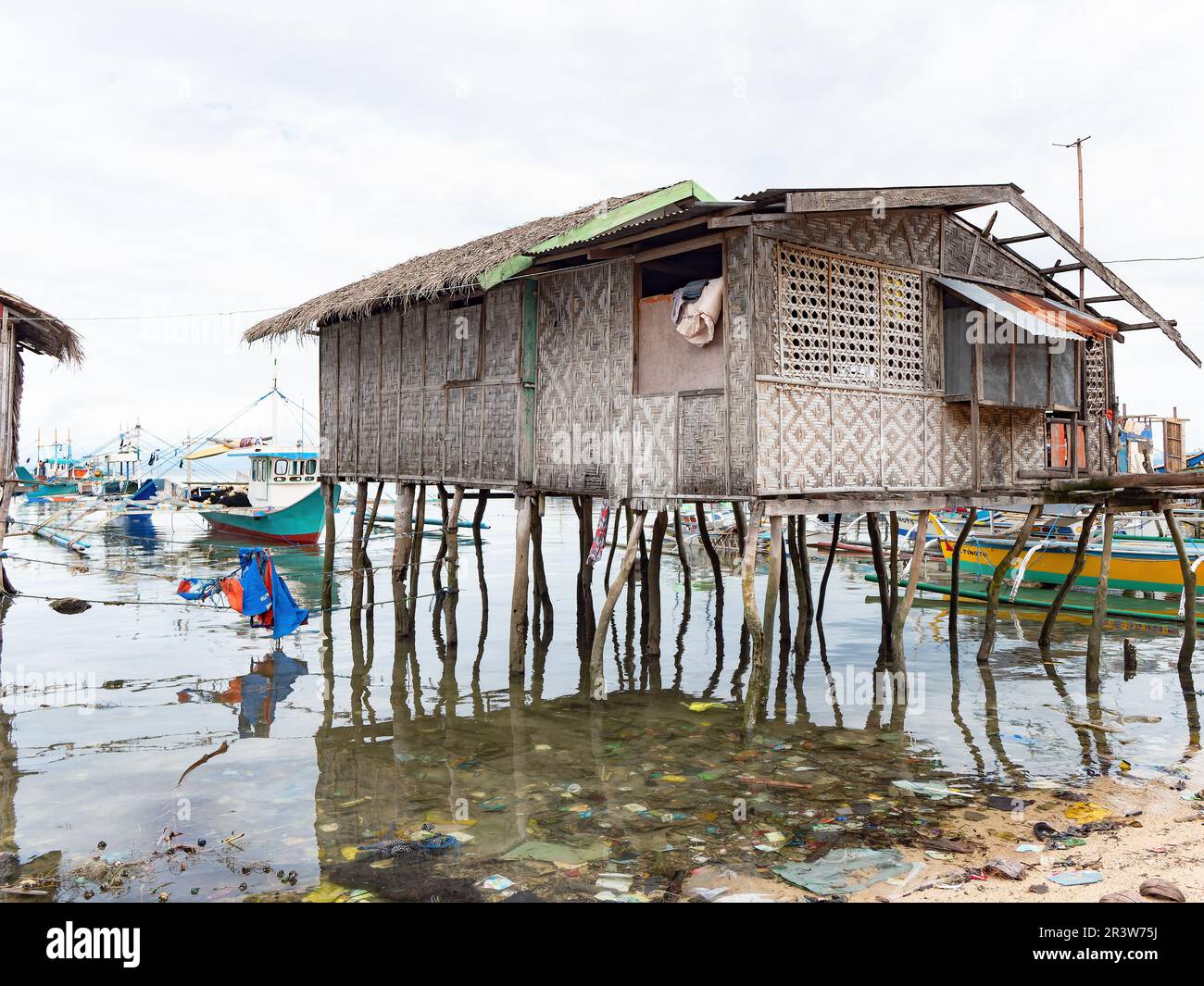 Une maison de pêcheur traditionnelle dans une mer de la malbouffe à ce qui était autrefois une plage vierge dans le village de Tinoto, Maasim, province de Sarangani à l'extrême Banque D'Images