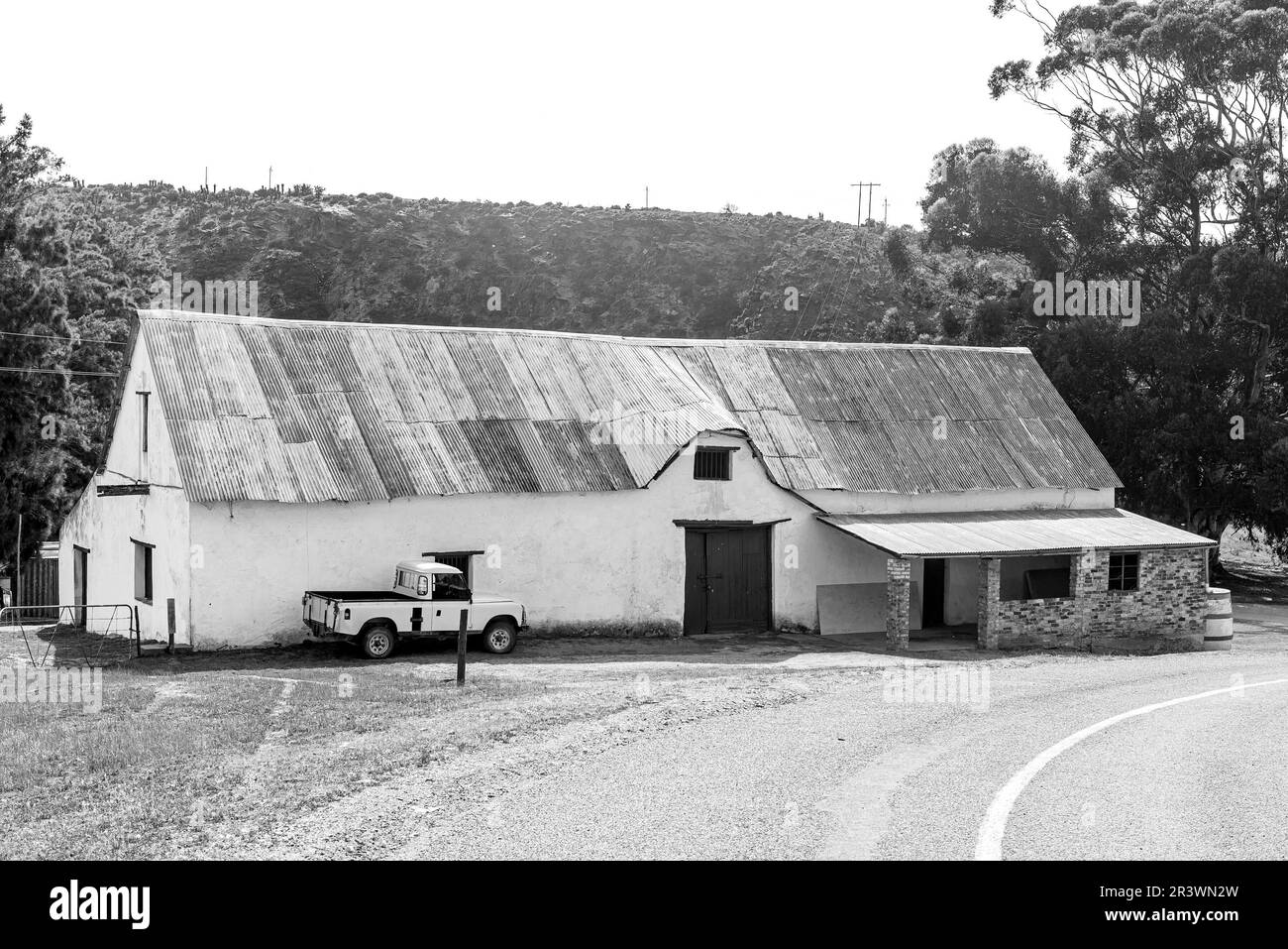 Malagas, Afrique du Sud - 24 septembre 2022 : un ancien bâtiment à Malagas, un hameau sur la rivière Breede dans la province du Cap occidental. Un pick-up 4x4 jaune Banque D'Images