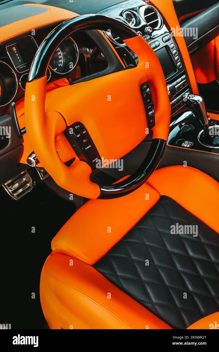 Vue de l'intérieur d'une automobile moderne montrant le tableau de bord. Réglage. Voiture de luxe orange Banque D'Images