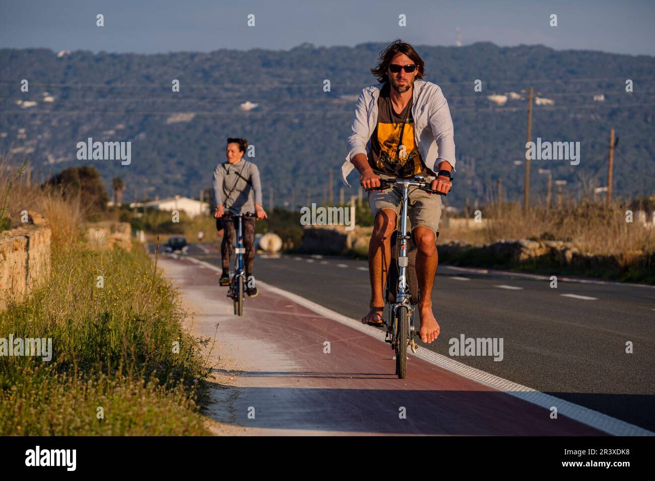 Cyclistes sur la route principale, Formentera, Iles Pitiusa, Communauté des Baléares, Espagne. Banque D'Images