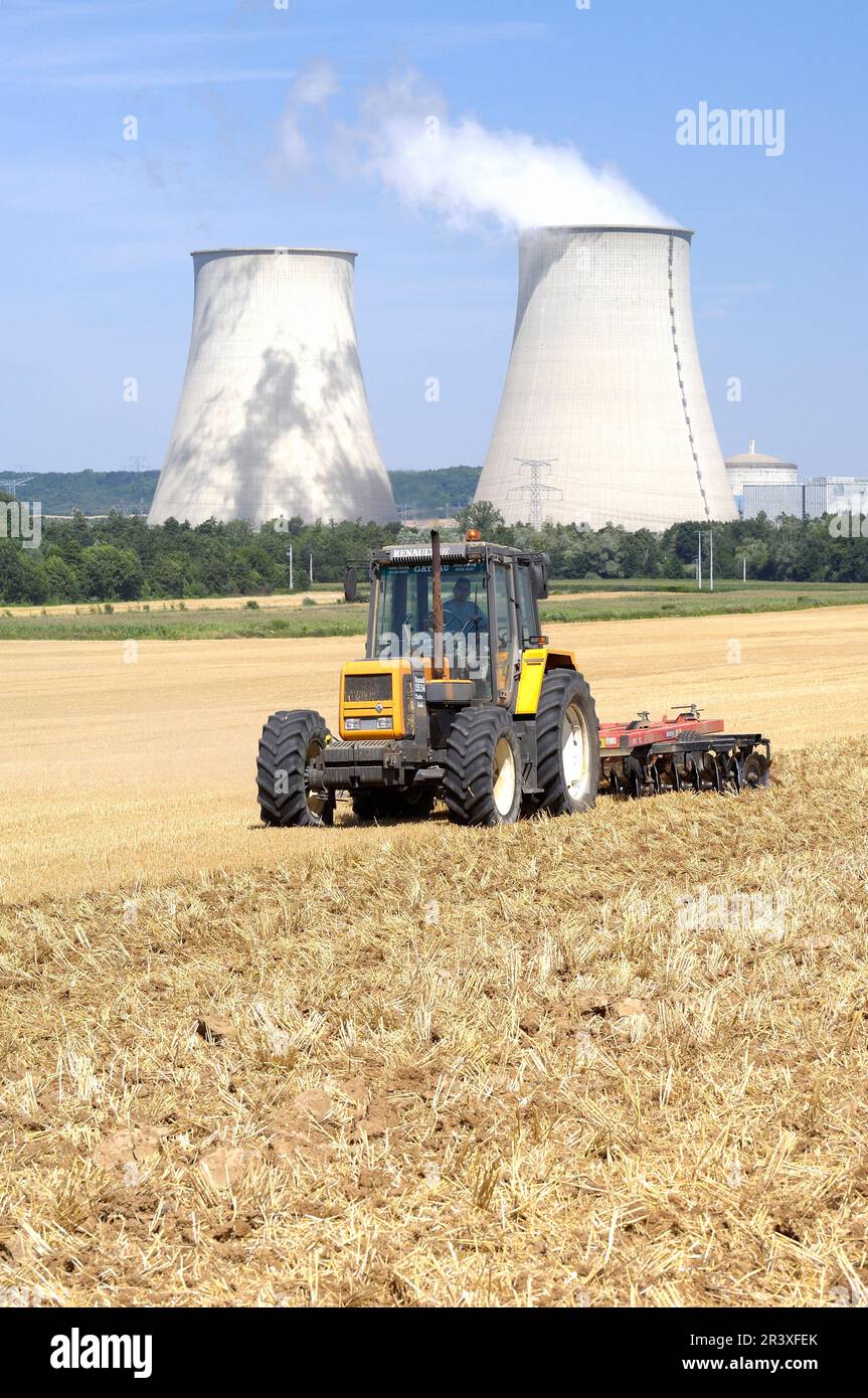 Agriculture près de la centrale électrique EDF de Nogent-sur-Seine (centre-nord de la France) : tracteur et tour de refroidissement. Tracteur dans un champ, labourage de chaume, shal Banque D'Images