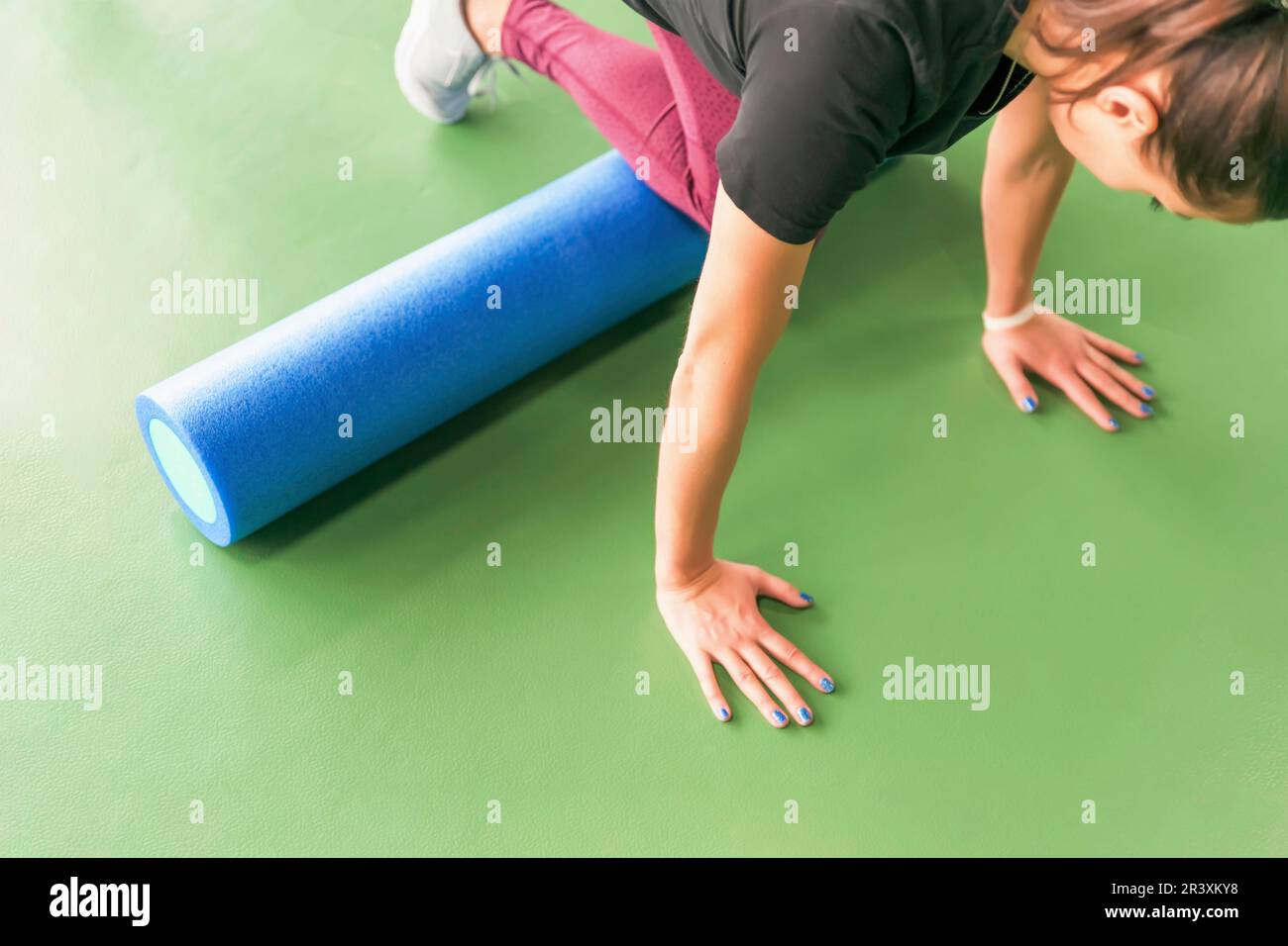 Femme attrayante rouleau mousse faisant de l'exercice et de poser dans un centre de remise en forme moderne Banque D'Images