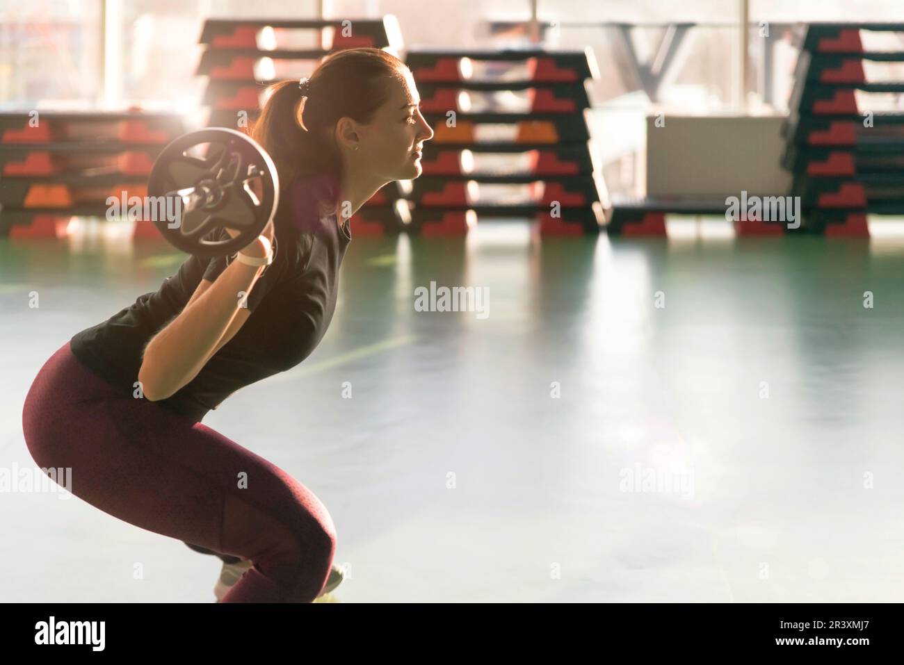 Fitness, sport, powerlifting et concept de personnes - femme sportive s'exerçant avec le barbell dans la salle de gym Banque D'Images