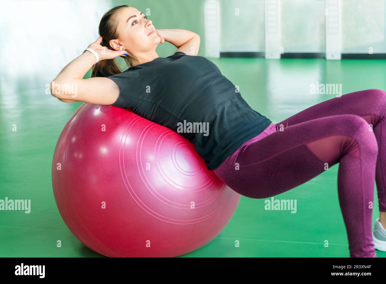 Femme à la salle de sport de faire les exercices avec ballon pilates sur son dos Banque D'Images