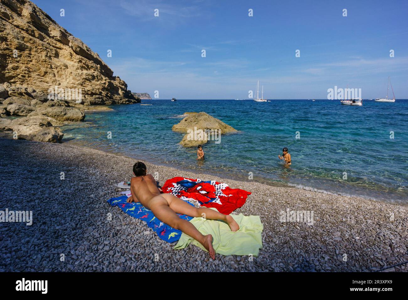 Mujer desnuda soleandose,playa de es Coll Baix, a los pies del Puig de sa Talaia, Alcudia, Mallorca, Espagne. Banque D'Images