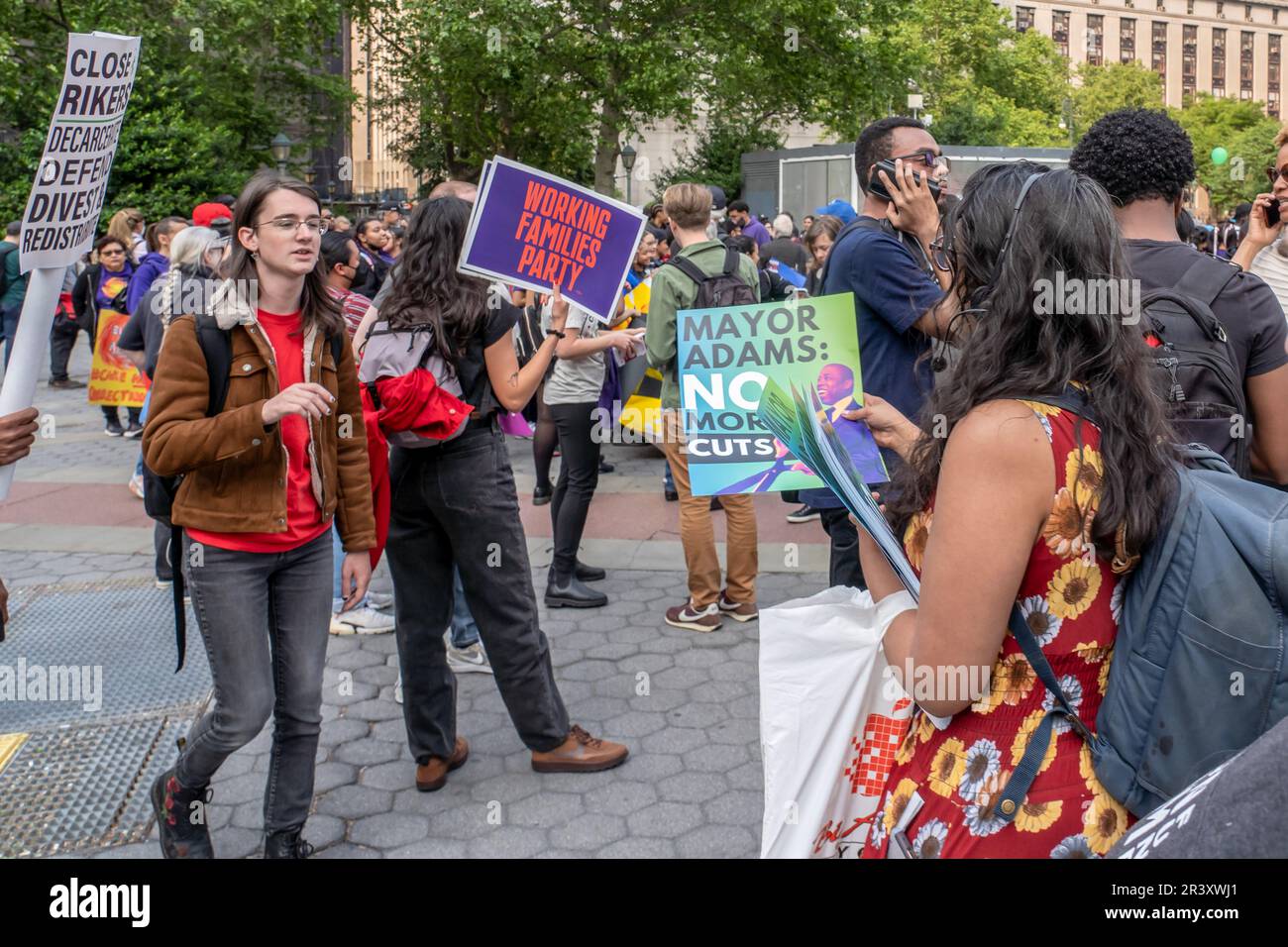 New York, États-Unis. 24th mai 2023. Militante distribue des pancartes appelant le maire Adams à mettre fin aux compressions budgétaires lors d'un rassemblement et d'une marche. Des manifestants représentant plusieurs groupes et organisations se sont rassemblés au parc Foley Square pour un rassemblement et ont défilé au parc de l'hôtel de ville pour protester contre les réductions budgétaires du maire Eric Adam. Deux manifestants ont été arrêtés par des policiers du département de police de New York (NYPD). Crédit : SOPA Images Limited/Alamy Live News Banque D'Images