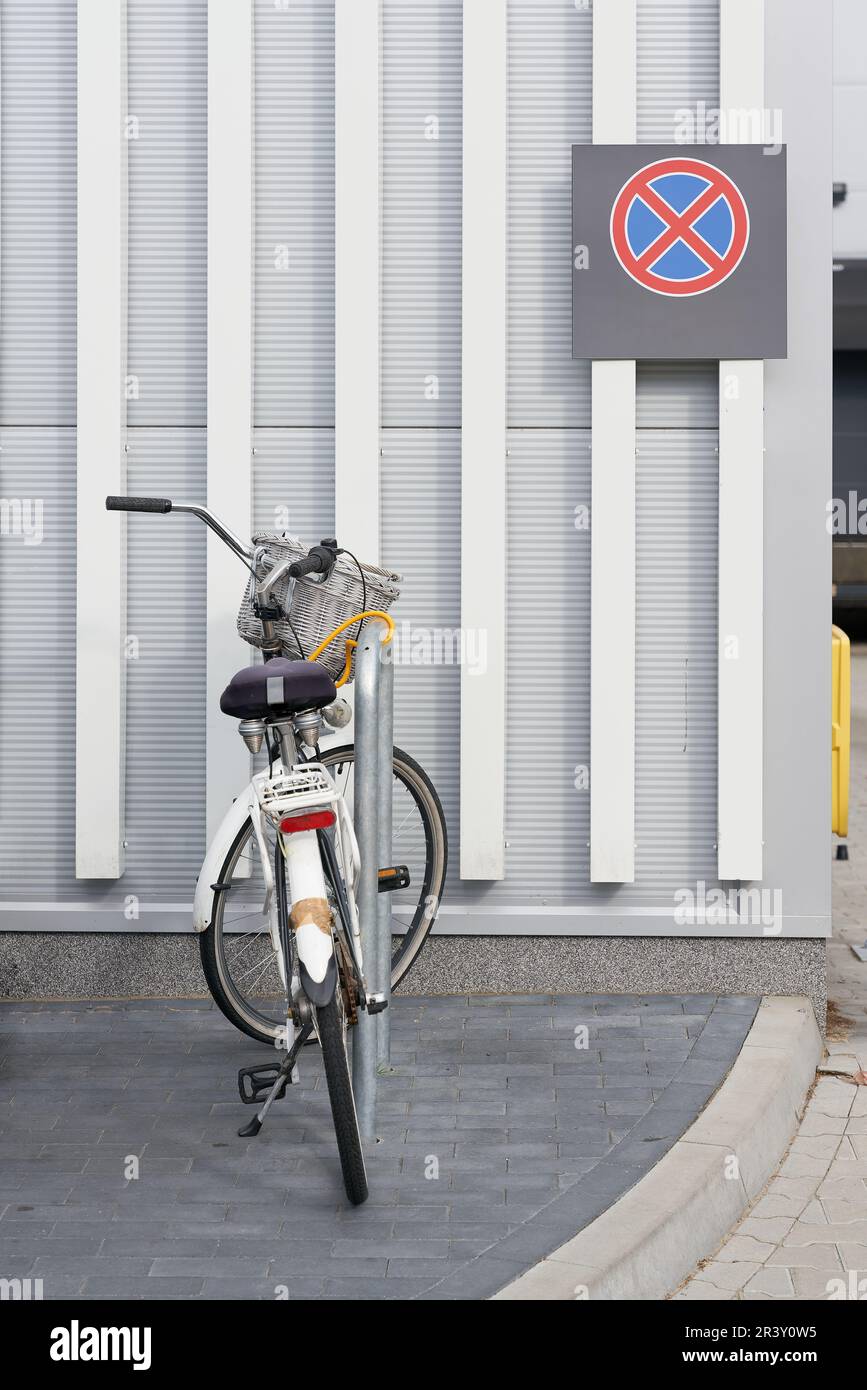 Bicyclette garée dans un supermarché, derrière elle un panneau de non-arrêt sur le mur Banque D'Images