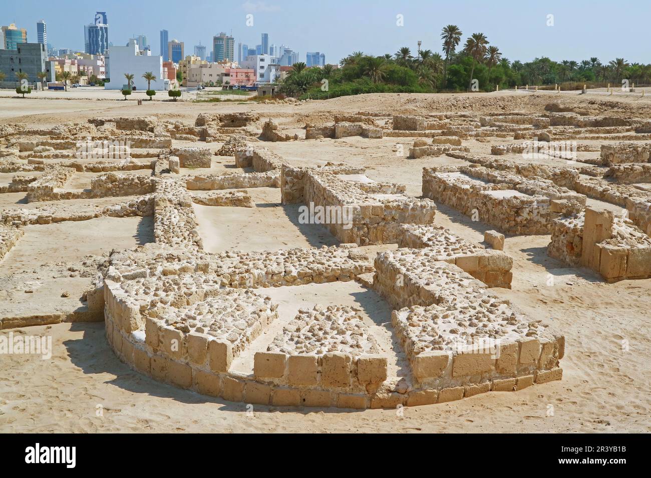 Ruines du fort de Bahreïn ou de Qal'at al-Bahrain avec Manama Modern Cityscape en toile de fond, Bahreïn Banque D'Images