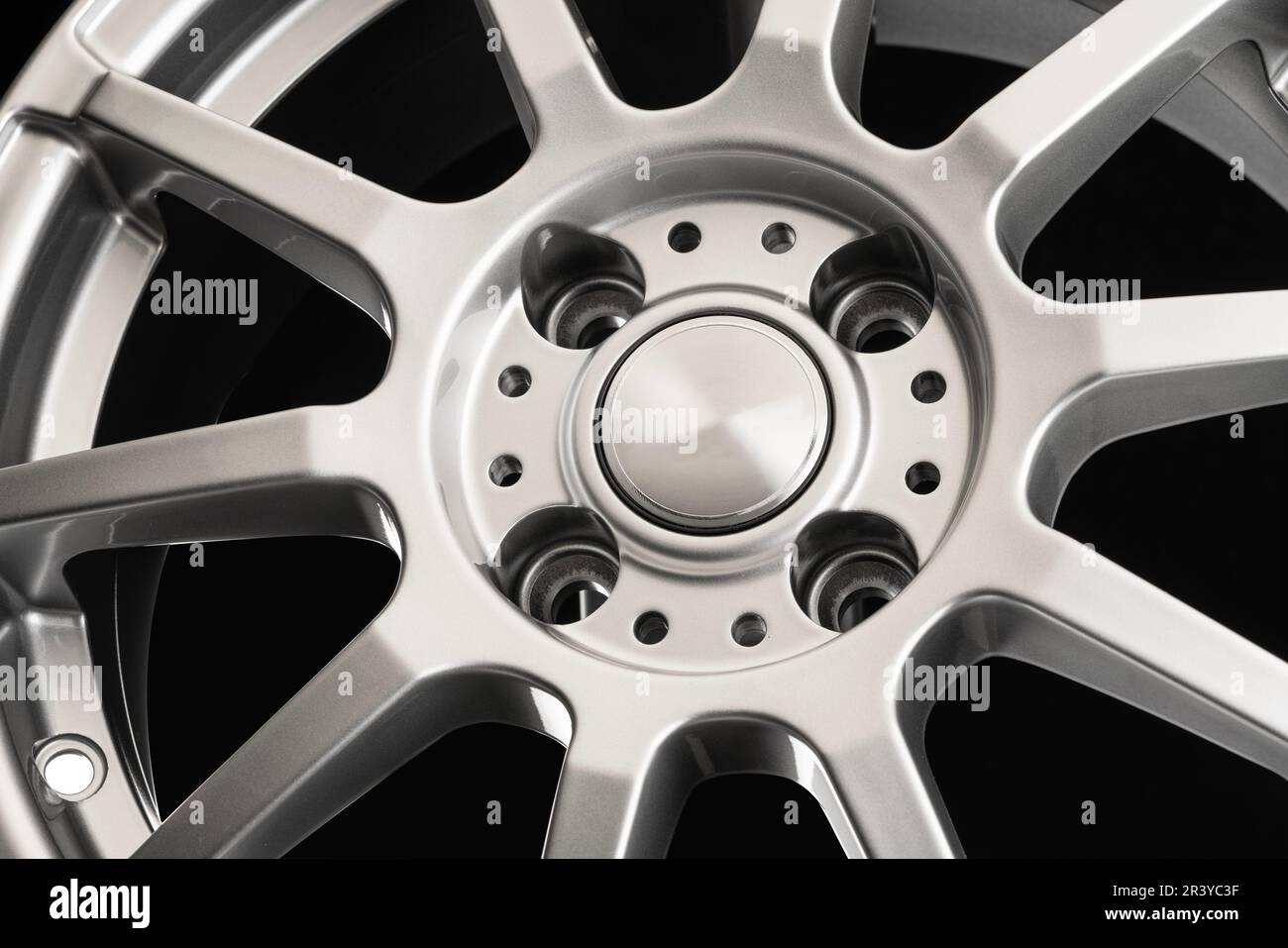 Disque sport en aluminium moulé avec branches fines gros plan sur fond noir, conception légère. Banque D'Images