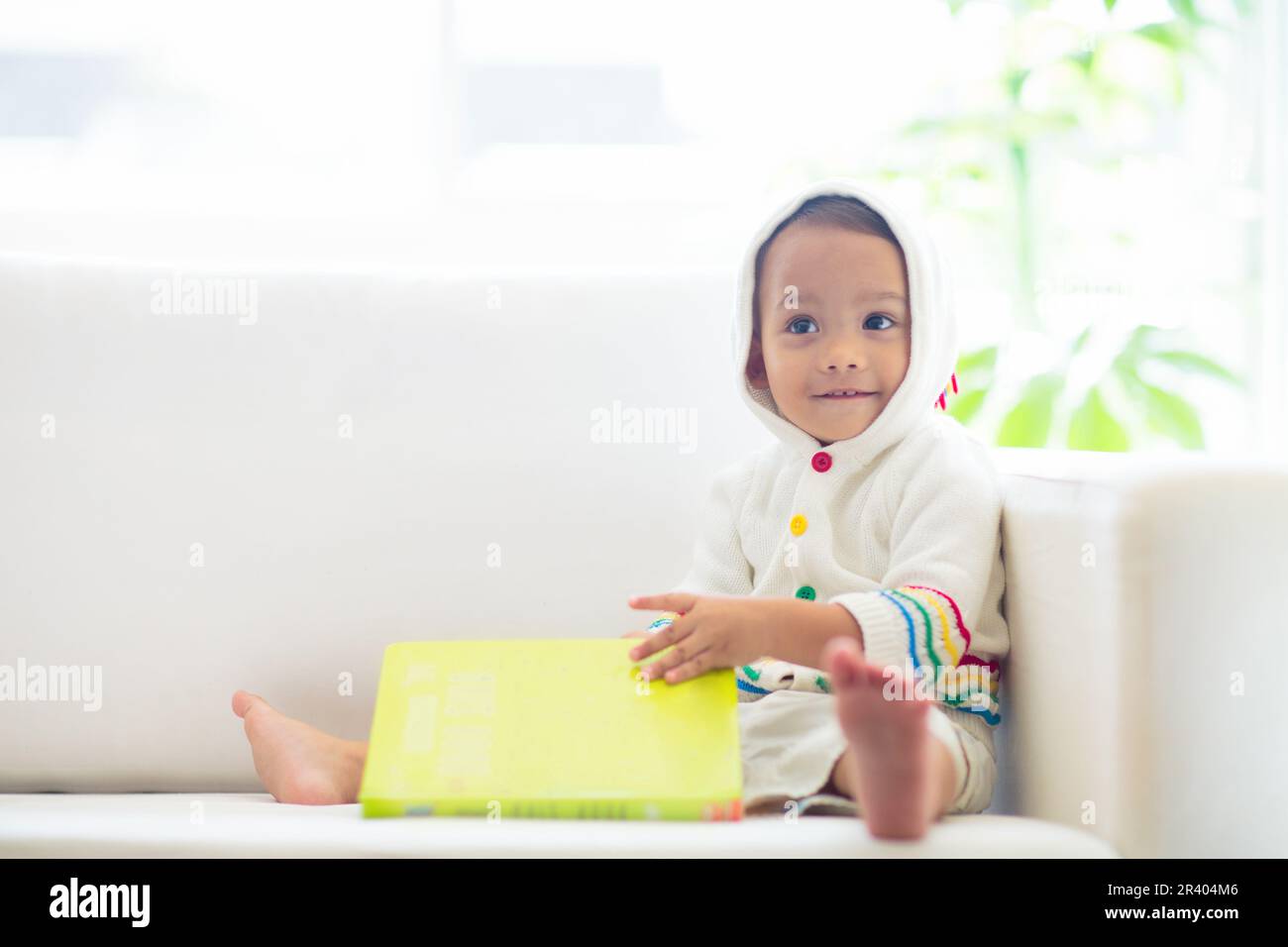 Bébé garçon lisant un livre. Les enfants lisent. Adorable enfant asiatique tenant un livre amusant et coloré d'âge préscolaire. Développement précoce et éducation. Banque D'Images