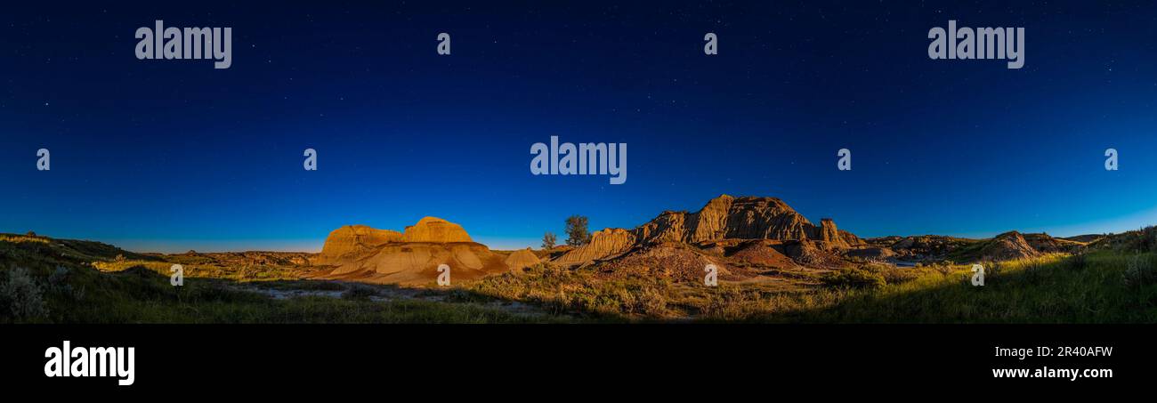 Les étoiles du ciel du nord se sont situées au-dessus des formations des badlands dans le parc provincial Dinosaur, Alberta, Canada. Banque D'Images