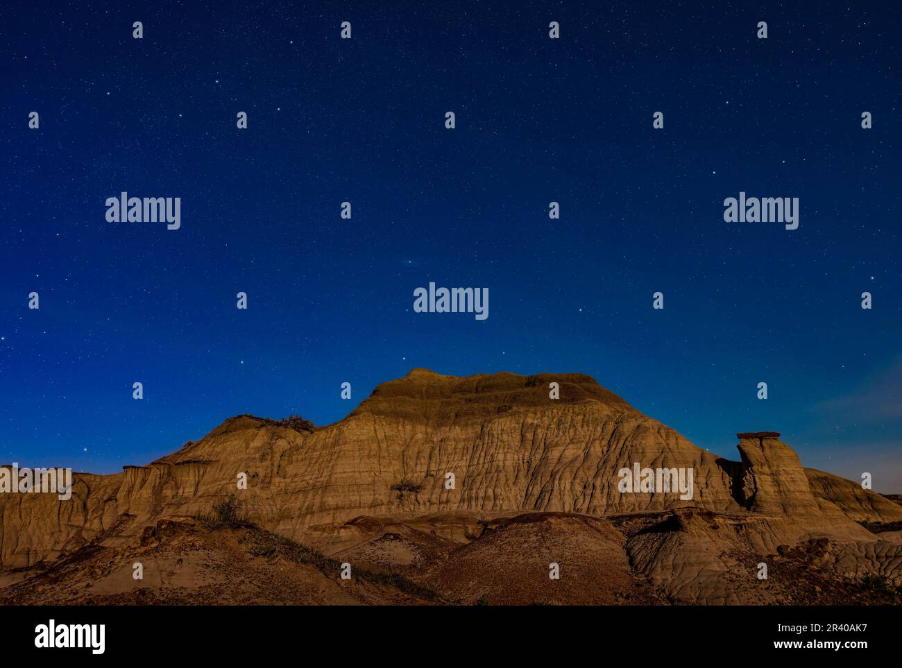Andromedia, Cassiopeia et Pegasus s'élèvent au-dessus de formations au clair de lune au parc provincial Dinosaur. Banque D'Images
