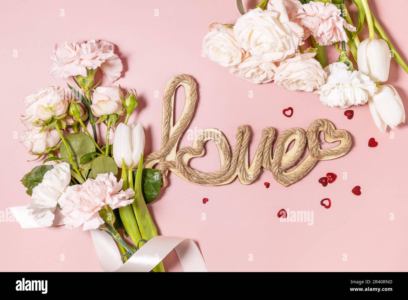 Le fond de la Saint-Valentin avec des lettres d'amour et de belles fleurs de printemps sur fond rose clair. Saint-Valentin, Saint-Valentin, Banque D'Images