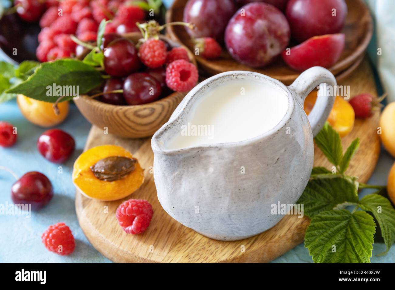 Ingrédients pour un smoothie sain. Lait et baies (framboise, cerise, prune, abricot) sur une table en pierre. Alimentation saine, alimentation crue et végétalien f Banque D'Images