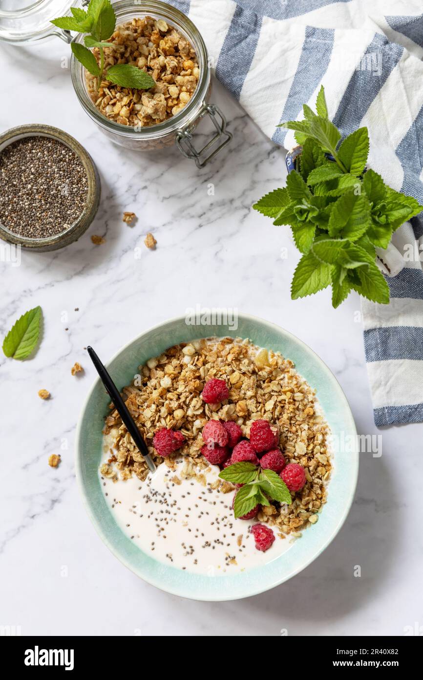 Petit déjeuner, dessert sucré. Concept de nutrition de régime. Granola maison avec yaourt, graines de chia et framboise sur une table en marbre. V Banque D'Images