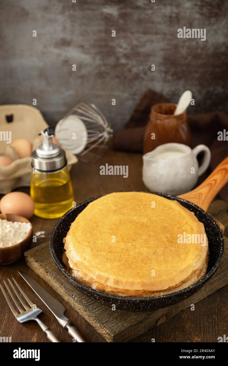 Fêtez le jour du Pancake, cuisinez un petit déjeuner sain. Crêpes ou crêpes maison délicieuses dans une poêle et ingrédients sur une r Banque D'Images