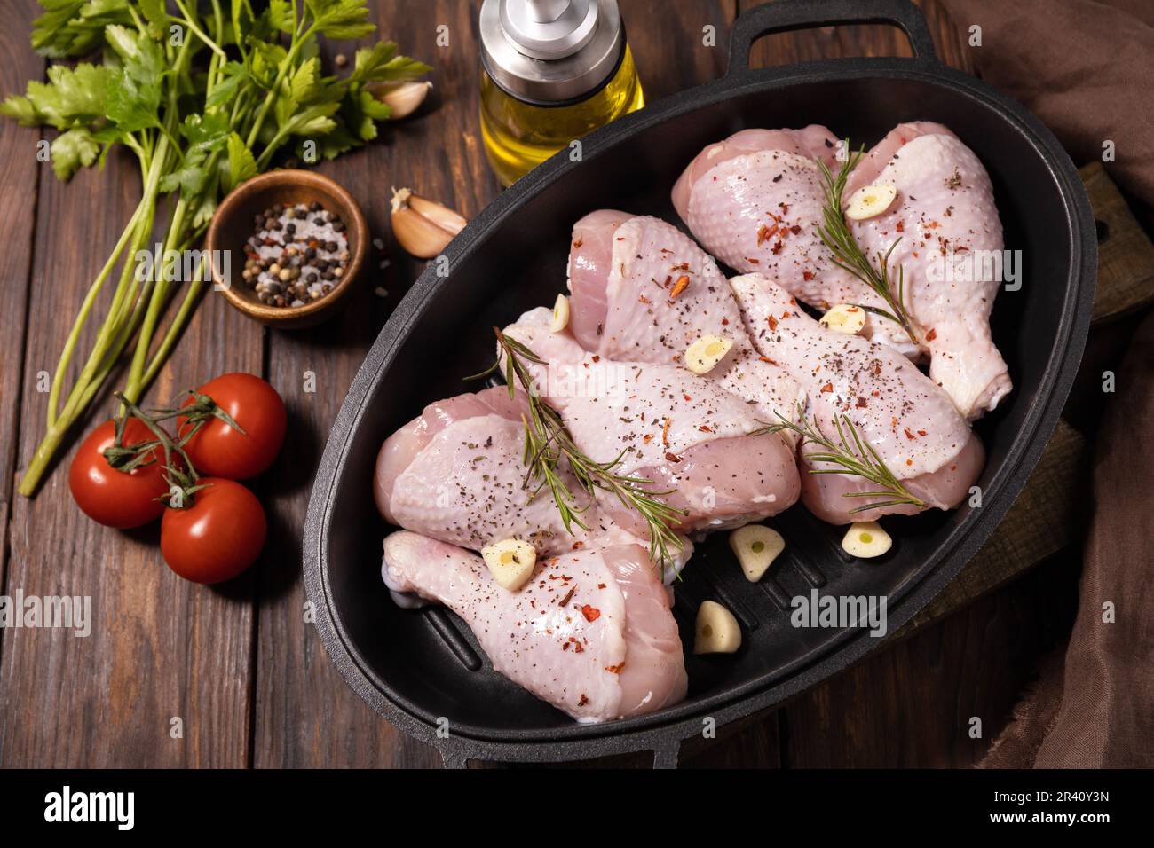 Viande de poulet crue. Pattes de poulet non cuites sur fond de table de cuisson en bois avec épices. Banque D'Images