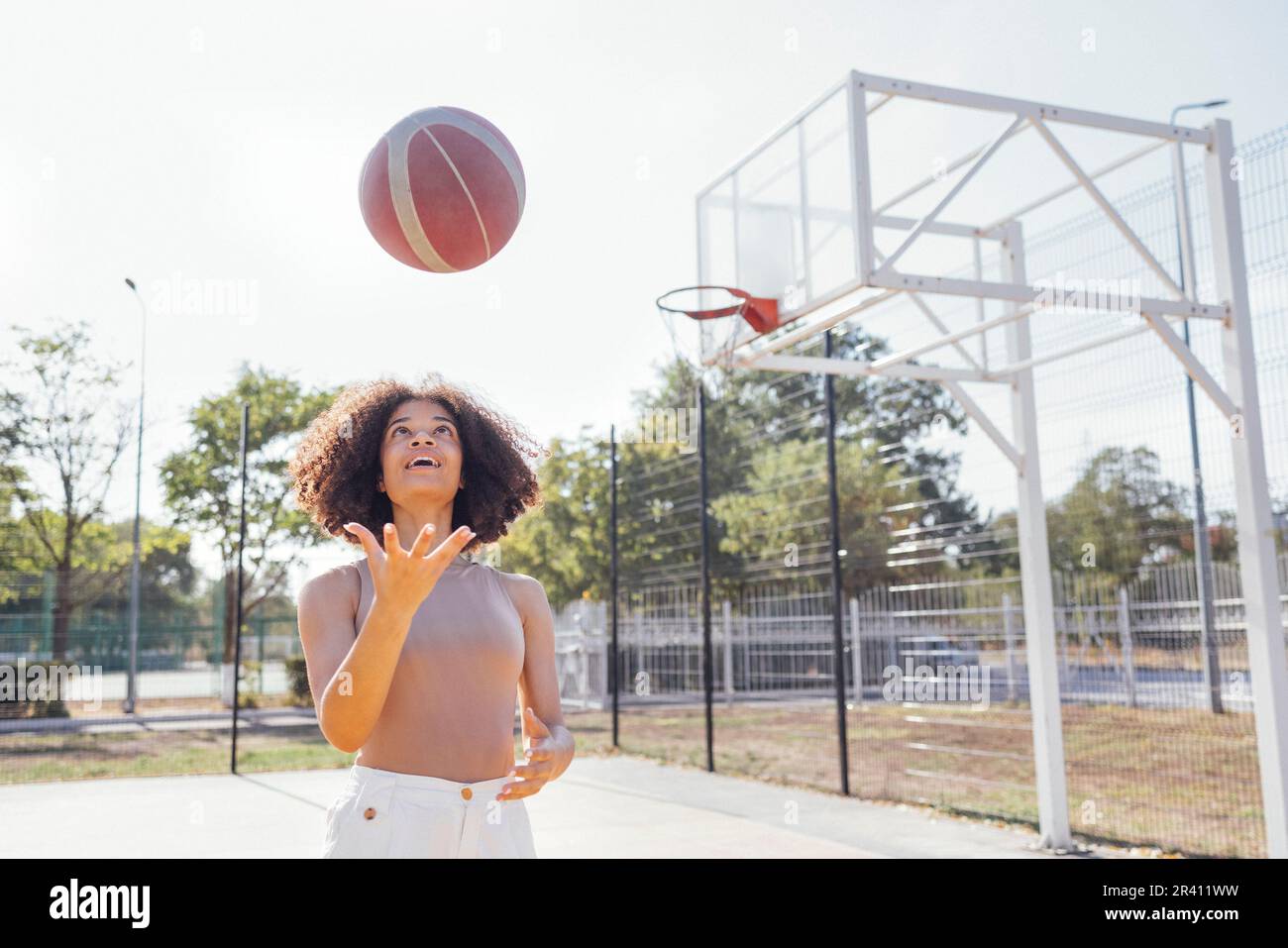 Une jeune fille élégante et fraîche se réunit sur le terrain de basket-ball, jouant au basket-ball à l'extérieur Banque D'Images