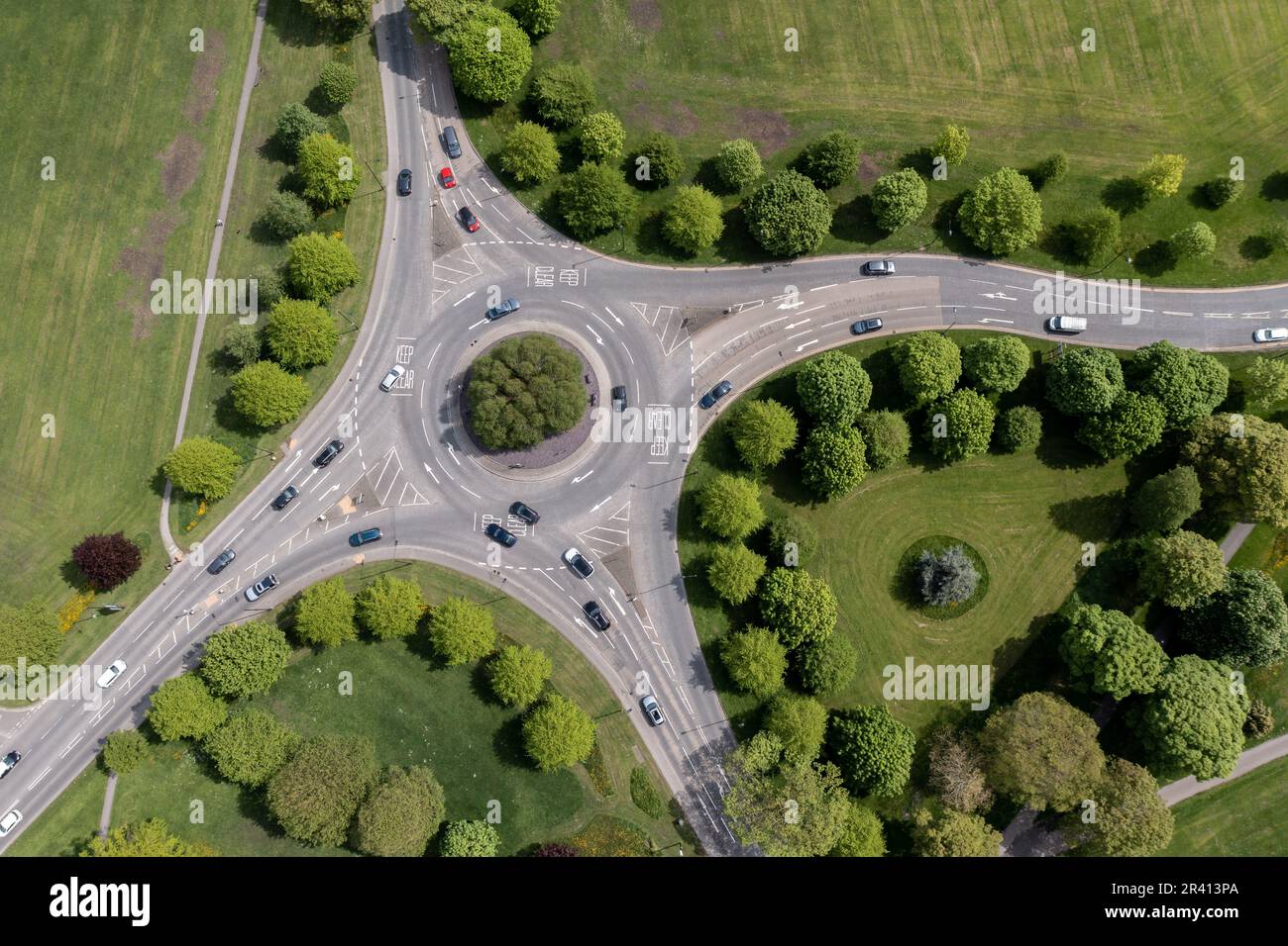 Vue aérienne directement au-dessus d'un rond-point à Harrogate, dans le North Yorkshire, avec rues bordées d'arbres et circulation en mouvement Banque D'Images