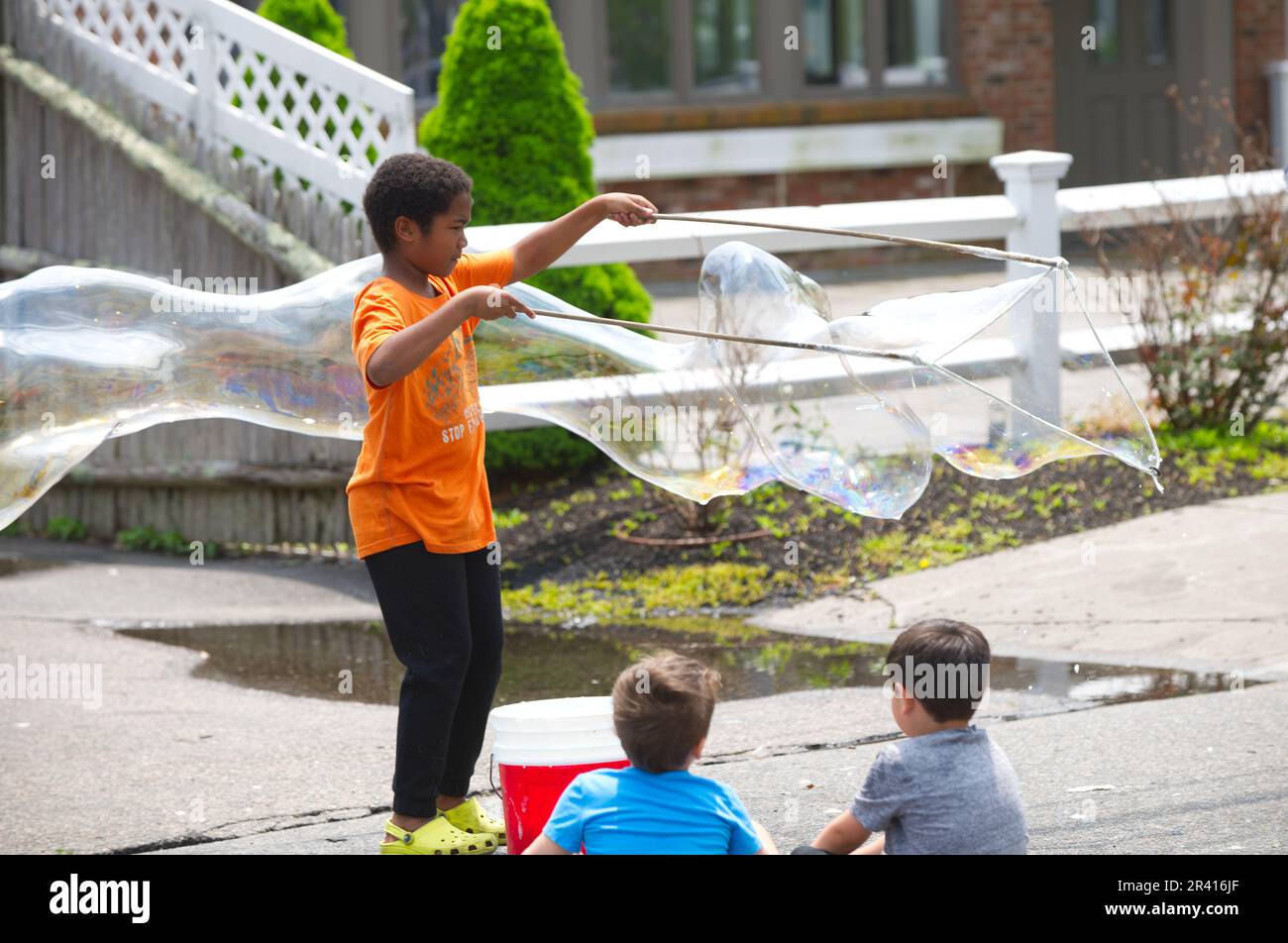 Rues ouvertes - Hyannis, Massachusetts, États-Unis. Un jeune garçon qui fait des bulles sur main Street. Banque D'Images