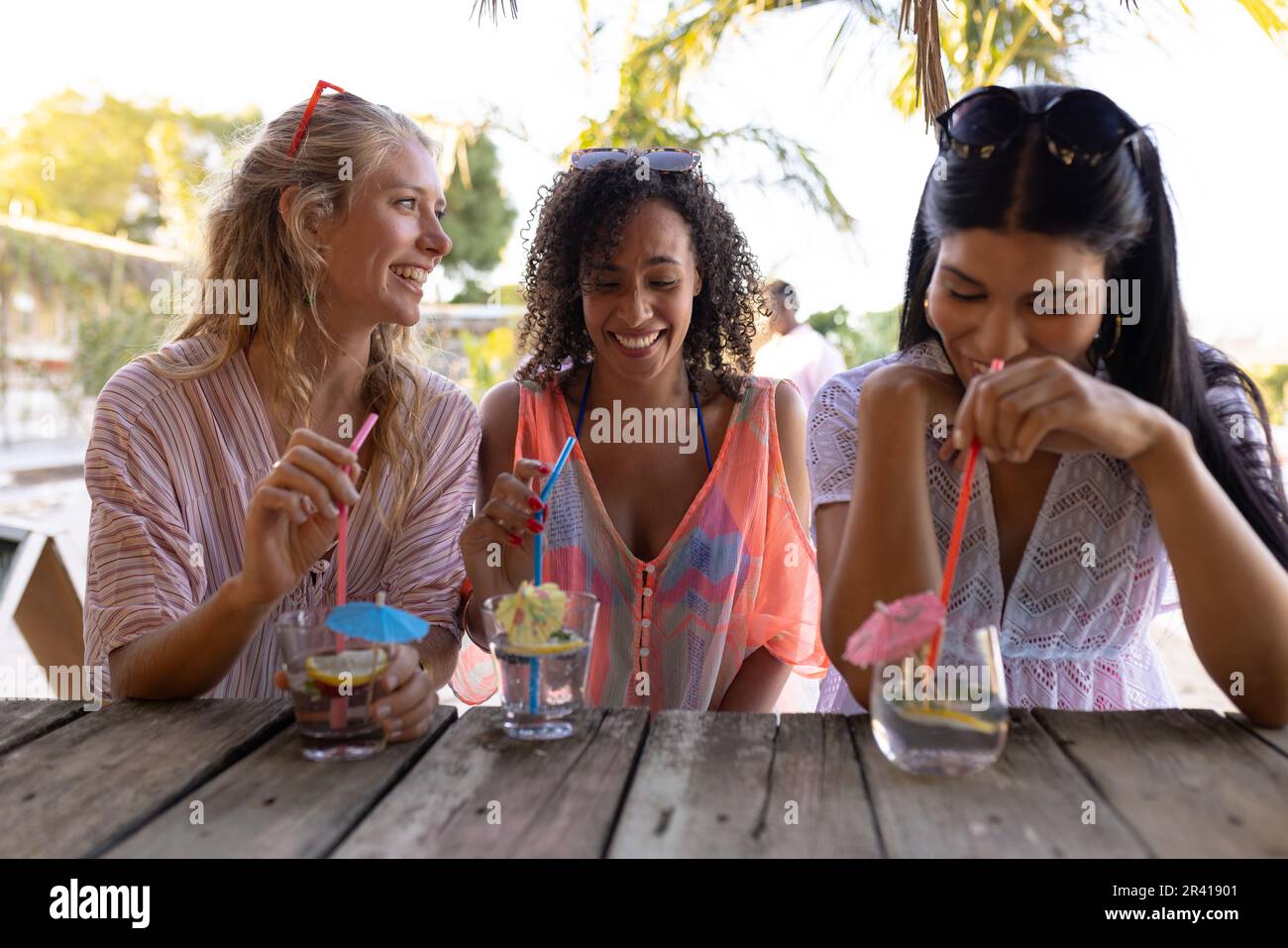 Heureux divers amis ayant la fête à la plage, boire des cocktails Banque D'Images