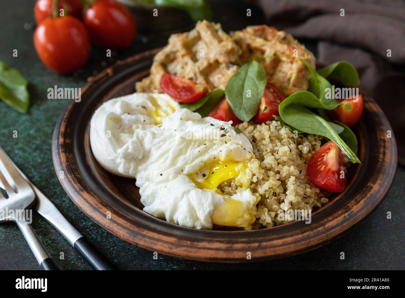 Régime de céto. Délicieux petit déjeuner ou brunch - gaufres végétaliennes à la courgette, œufs pochés, quinoa et salade de légumes frais sur un tabl en pierre Banque D'Images